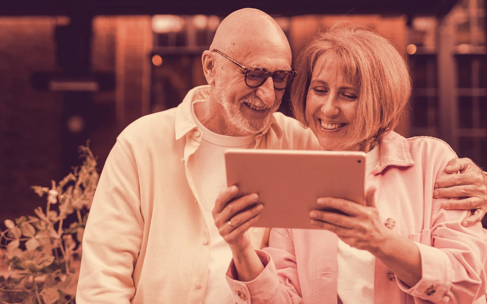 Older couple smiling at a tablet together